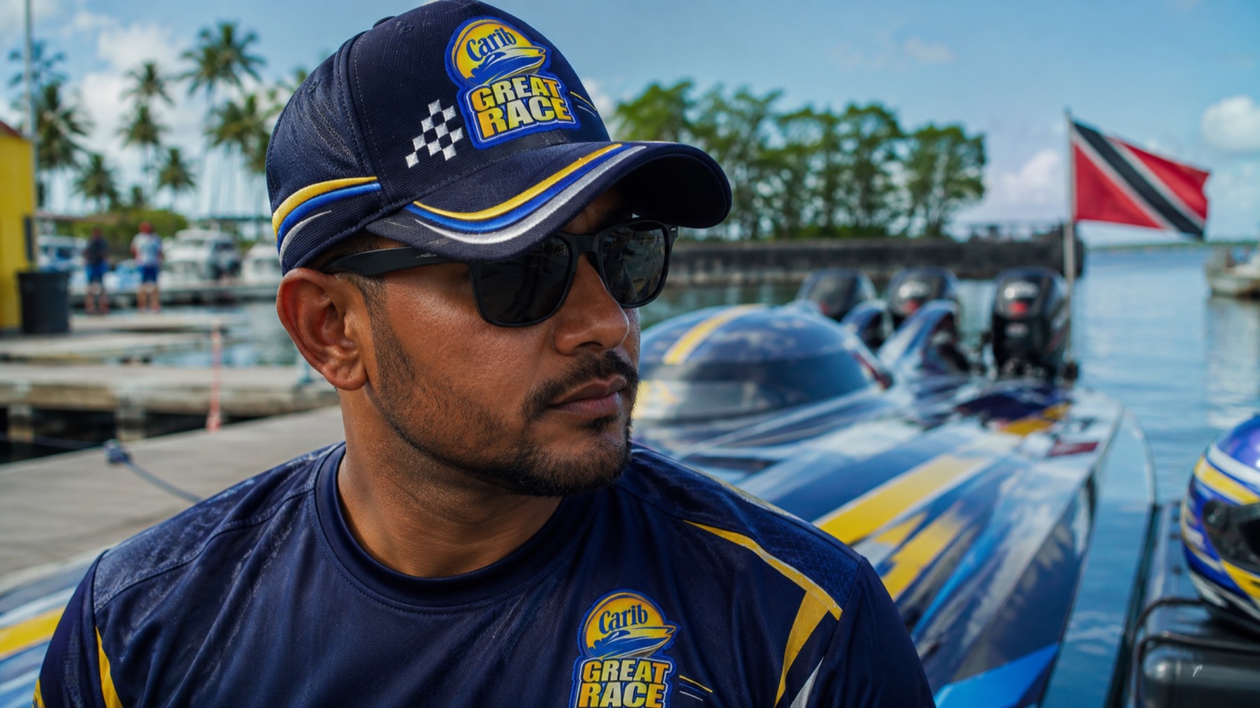 Carib Great Race team member beside a powerboat